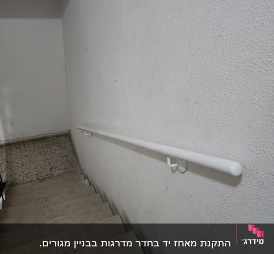 מעקה לבן מותקן על קיר מדרגות